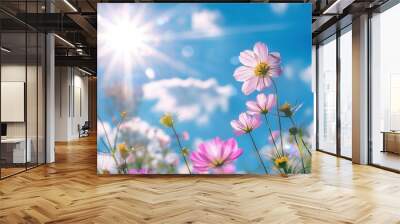 A field of flowers with a bright blue sky in the background Wall mural