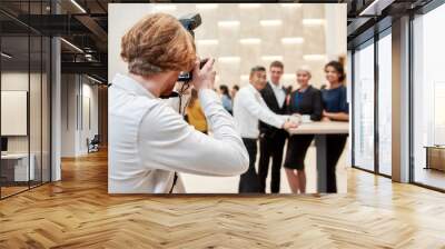 A moment to remember. Close up of photographer taking photo of businesspeople during coffee break at conference Wall mural