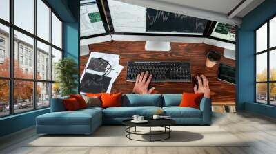 Achieve best. Top view of businessman, trader working, sitting by desk in front of multiple computer monitors. Stock trading forex with technical indicator tool. Hands on keyboard. Wall mural