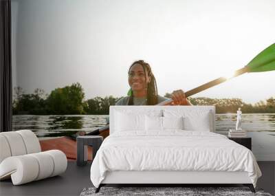 Active young woman smiling, enjoying a day kayaking together with her boyfriend in a lake on a late summer afternoon Wall mural