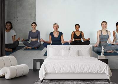 Banner portrait of smiling multiethnic women meditate together Wall mural