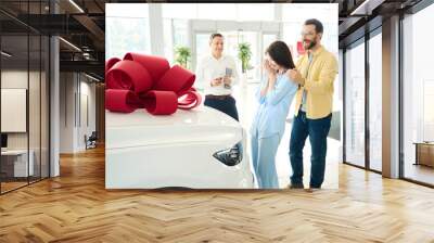 Buyers and manager stand in front of car with gift bow Wall mural