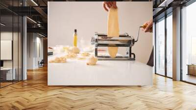 Careful cook using pasta machine in the kitchen Wall mural