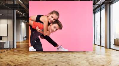 Champions. Two active teenagers boy and girl having fun together after workout isolated on pink background. Fitness, sport, training, active lifestyle concept Wall mural