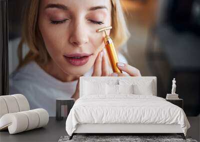 Charming cute lady taking facial care while spending time at home Wall mural