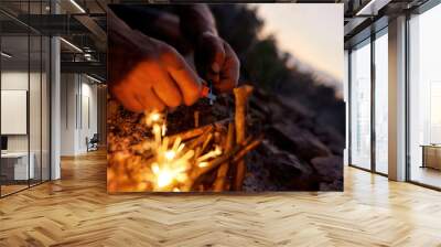 Close up of male hands making a fire with flint and steel in the wild Wall mural