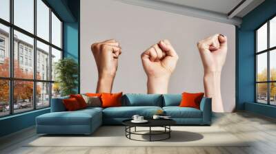 Close up of three raised fists of diverse women. Feminism, equality and women liberation concept Wall mural