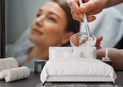 Cosmetician preparing a face mask for her female patient Wall mural