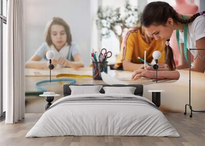 Cute female kids making sewing patterns in workshop Wall mural