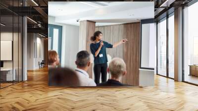 Dependable, professional partnership. Female speaker with laser pointer pointing at the screen while giving a talk on corporate business meeting Wall mural