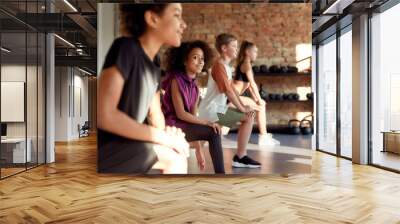 Do more everyday. Portrait of a girl smiling at camera while warming up, exercising together with other kids in gym. Sport, healthy lifestyle, physical education concept Wall mural