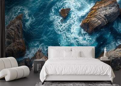 Dramatic Overhead Shot of Rugged Coastline. Natural Wallpaper, with Coastal Rocks and Crashing Waves. Wall mural