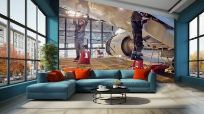 Engineer working on aircraft wing in aircraft maintenance factory Wall mural