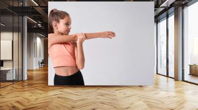 Fit kid. Flexible cute little girl child looking aside while doing exercise isolated on a white background. Sport, training, fitness, active lifestyle concept. Horizontal shot. Web Banner Wall mural