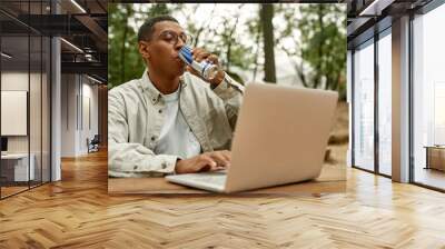 Happy young african american man drinking energy drink Wall mural