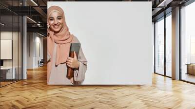 Happy young arabian girl in hijab talking on smartphone Wall mural