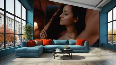 In the mood for love. Couple relaxing half dressed in living room. Boyfriend and girlfriend cuddling while having romantic evening together Wall mural