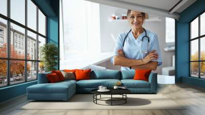 Joyful female doctor standing in her office in clinic Wall mural