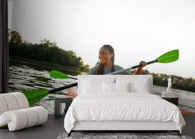 Joyful young woman smiling, enjoying a day kayaking together with her friend in a lake on a late summer afternoon Wall mural