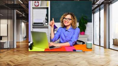 Learning, education and knowledge. Teacher job. University teacher sitting at desk in classroom showing thumb up. Smiling female student in glasses preparing for exam or test in college. High school. Wall mural