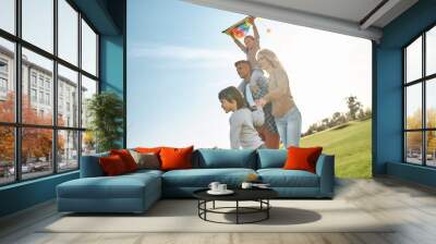 Let your children spread the wings. Happy family playing a kite. Outdoor family weekend Wall mural