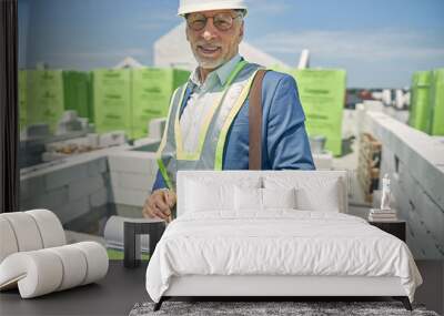 Male constructor standing at a building site Wall mural