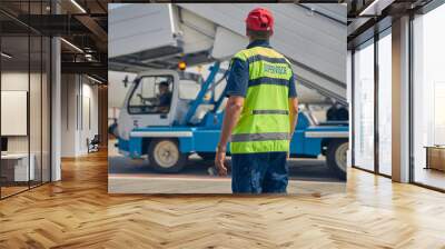 Man in a reflective vest looking at a vehicle operator Wall mural