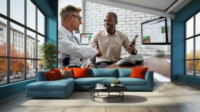 Move forward. Successful businessmen trading stocks. Stock traders looking at graphs, indexes and numbers on multiple computer screens. Two colleagues in modern office Wall mural