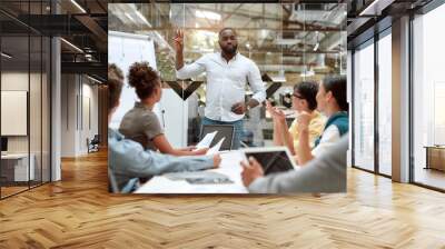 One team one goal. Confident afro american businessman standing near whiteboard and explaining something to his young colleagues while working together in the creative office Wall mural