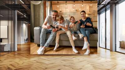 Overjoyed family with kids play video games at home Wall mural