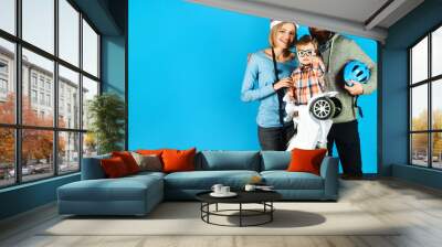 Parenthood, happy childhood. Sports family in safety helmet. Kid sport activities. Child boy in helmet and glasses with toy car. Happy mother and father in protective helmet. Vacation and leisure. Wall mural