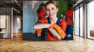 Pleased female janitor posing for the camera at work Wall mural