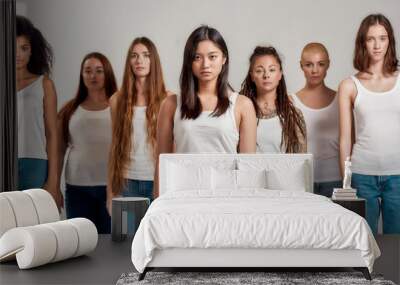 Portrait of beautiful young asian woman in white shirt looking at camera. Group of diverse women posing, standing isolated over grey background Wall mural