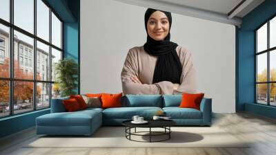 Portrait of smiling young arabian girl in black hijab Wall mural