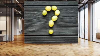 Question Mark from white grapes on black wooden background Wall mural