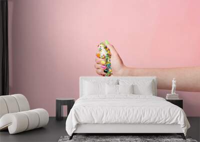 Say no to sugar. Female hand squeezing donut on pink background Wall mural