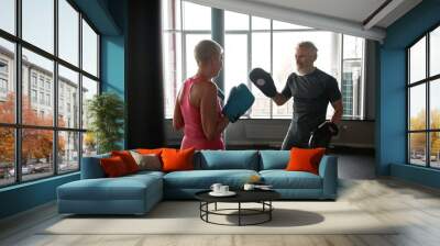 Senior man and woman boxing in gym Wall mural