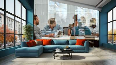 Setting Goals. Group of business people communicating and discussing fresh ideas while sitting together behind the glass wall in the meeting room Wall mural