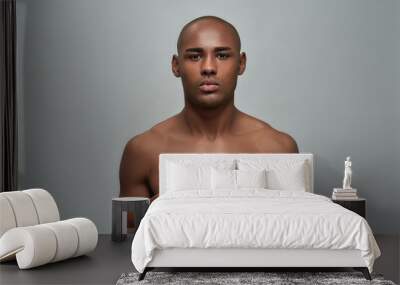 Shirtless young african american man looking at camera, choosing between two different types of shaving razors isolated over grey background Wall mural