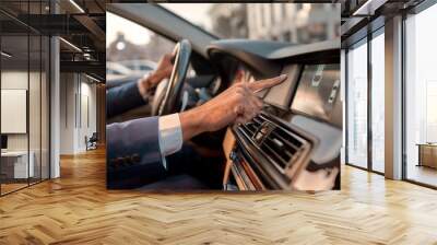 Smart parking. Cropped photo of a man using parking assist system while sitting in the car Wall mural