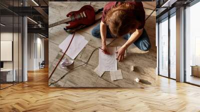 Top view of man writing text of new song on paper Wall mural