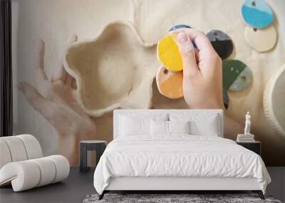 Woman holds handmade plate and paint swatches in her palms Wall mural