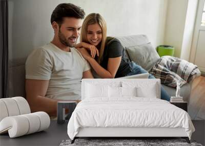 Young couple watching something funny on laptop and chilling Wall mural