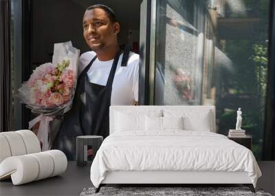 Young man standing with flowers in the doorway Wall mural