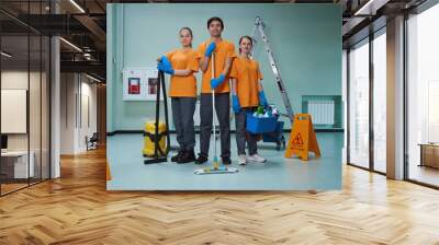 Young workers of cleaning company posing with their tools Wall mural