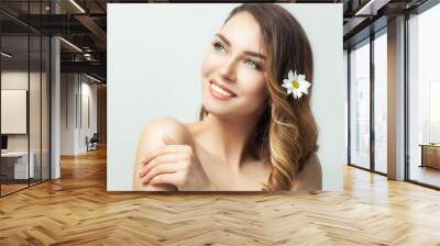 Close up portrait of beautiful young lady with clean pure skin and natural nude make up with wreath of flowers over white background. Wall mural