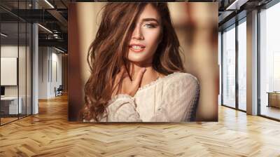 Close up portrait of young beautiful woman with green eyes and long healthy hair in the street. Hot sunny evening. lifestyle concept. Wall mural