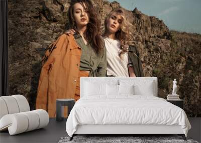 High fashion portrait of two stylish beautiful woman in trendy jackets and jeans posing outdoor. Vogue style. Wall mural