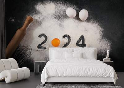 Creative Happy New Year 2024 greeting card for home baker. Numbers made out of flour with egg yolk, Christmas baking concept, top view Wall mural