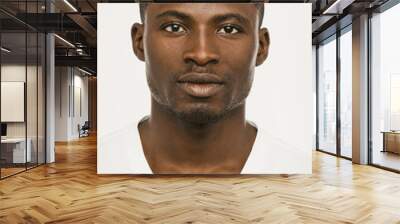 Attractive African american man looking seriously at the camera, Dark-skinned guy in a white t-shirt on a white background looks confident, cut out on white. Toned image Wall mural